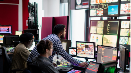 Medewerkers kijken in de control room mee op de verschillende schermen