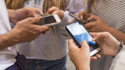 Groep jongeren op straat met hun mobiele telefoons