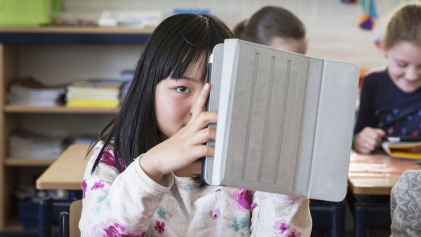 Een meisje houdt haar tablet vast in de klas op een tabletschool in Lopik