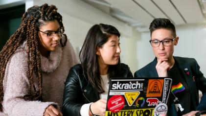Drie mensen aan het werk op een laptop