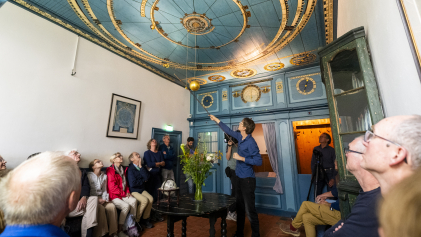 Bezoekers van het Eise Eisinga Planetarium krijgen uitleg over de werking ervan.