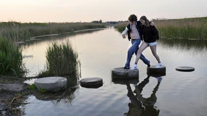 Samen stappen maken over stenen in het water