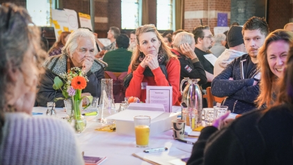 Mensen aan een tafel die naar elkaar luisteren