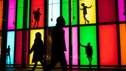 Mensen lopen langs kunstwerk van etalages met felle kleuren