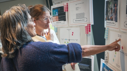 Twee mensen wijzen naar een poster
