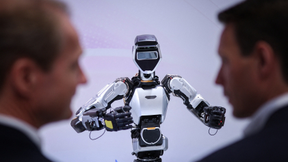 Twee mannen in pak die naar een rotot kijken