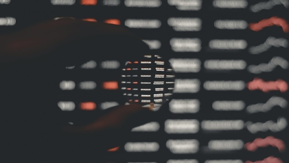 Een hand die een knikker vasthoud met op de achtergrond tekens en letters