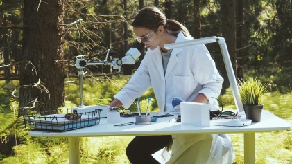 Vrouw aan bureau met apparaat, in de natuur