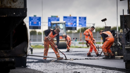 Mannen asfalteren snelweg.