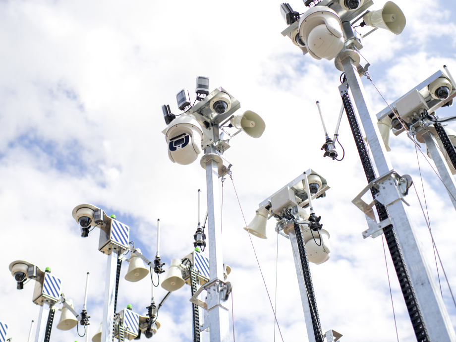 Een woud van surveillancecamera's tegen een bewolkte hemel