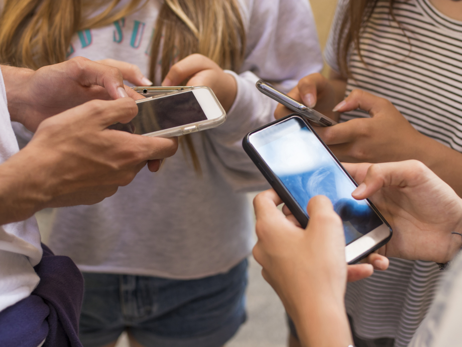 Groep jongeren op straat met hun mobiele telefoons