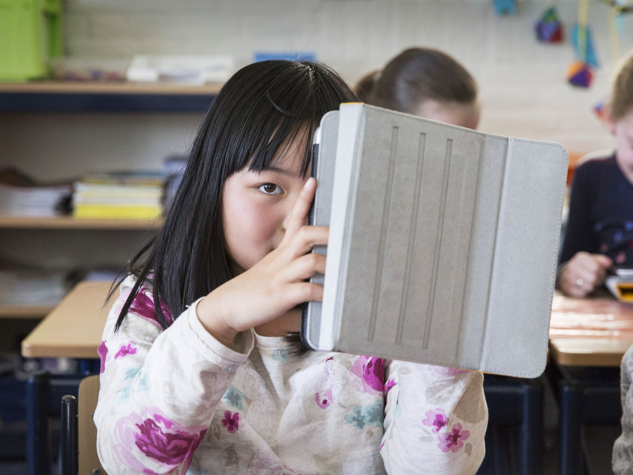 Een meisje houdt haar tablet vast in de klas op een tabletschool in Lopik