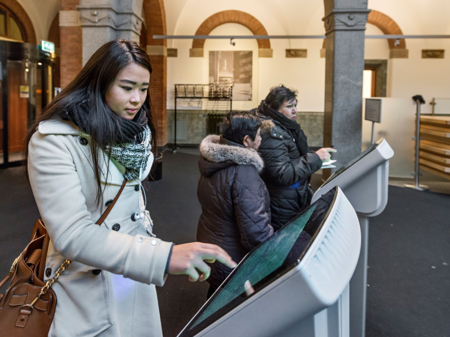 Een mevrouw trekt een nummer voor de balie van het Stadskantoor in Rotterdam