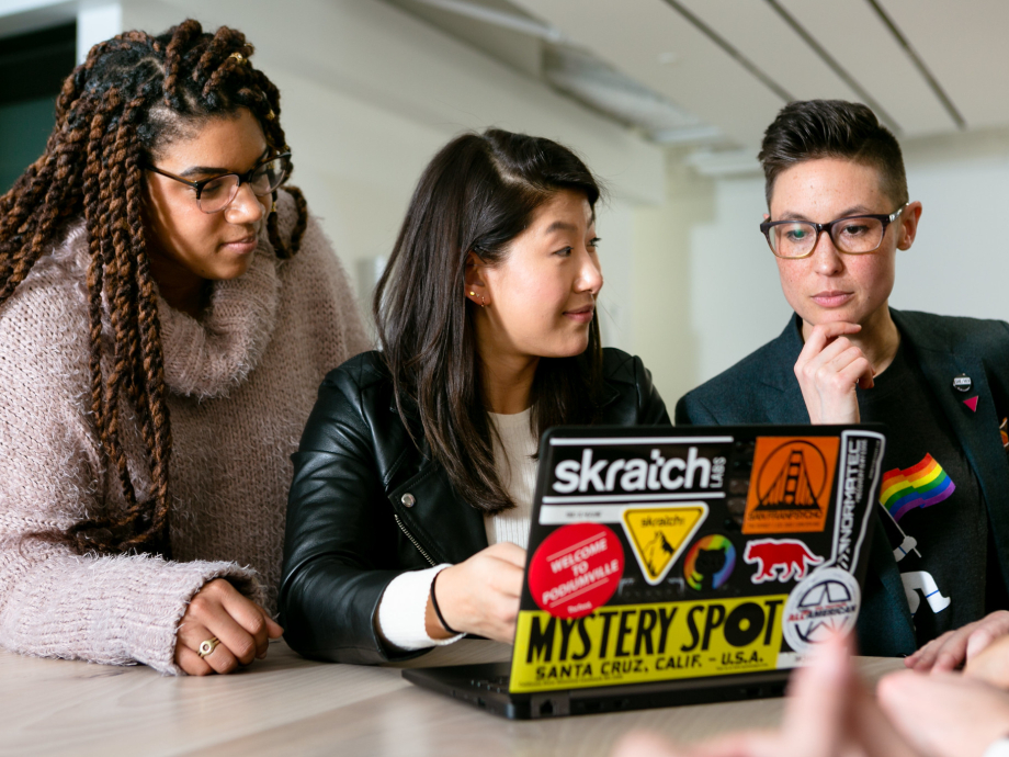 Drie mensen aan het werk op een laptop