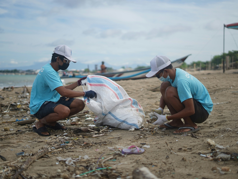 Vrijwilligers van OCG saving the ocean rapen afval op van het strand