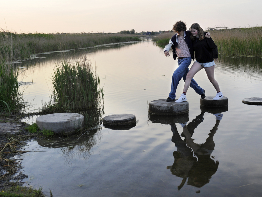 Samen stappen maken over stenen in het water