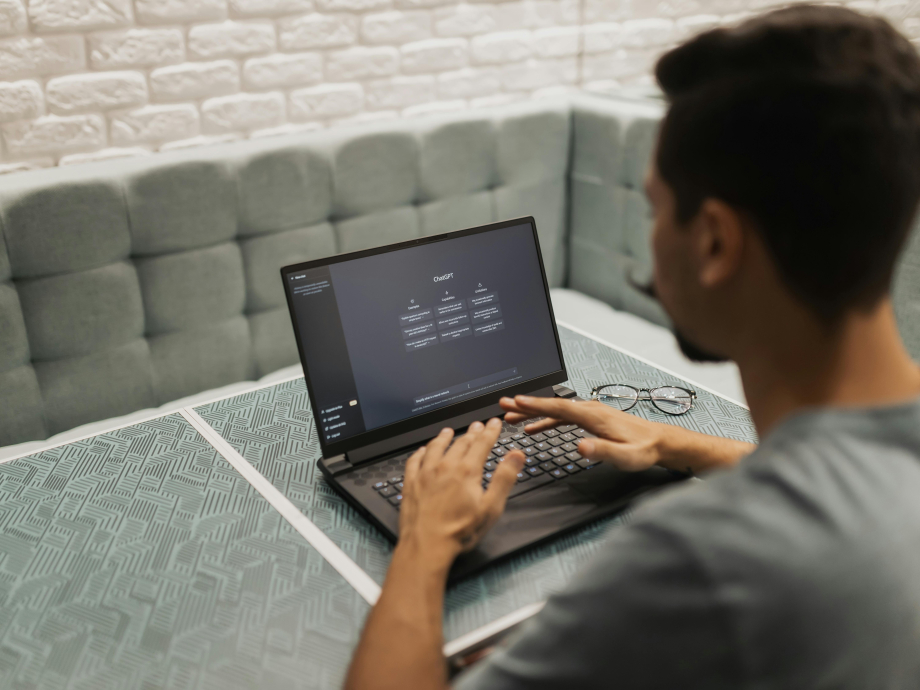 Man met laptop met daarop ChatGPT