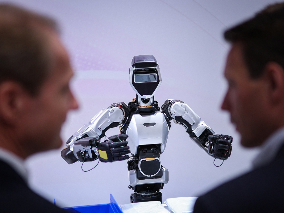 Twee mannen in pak die naar een rotot kijken