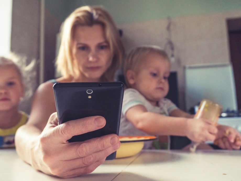 Vrouw met mobieltje en kinderen