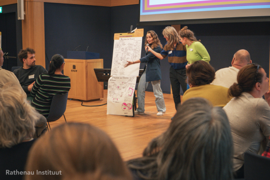 Tekenaar legt tekening uit