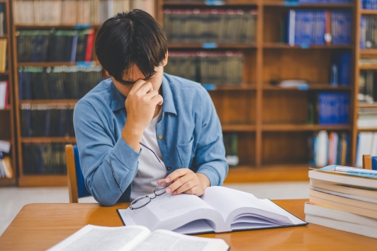 Boekenkast met vermoeide student 