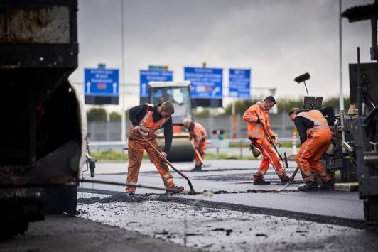 Mannen asfalteren snelweg.